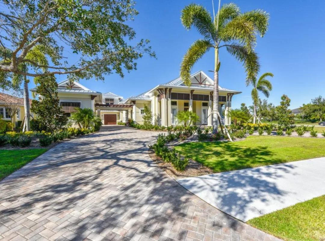 British West Indies luxury custom homeSarasota British West Indies luxury custom home with metal roof paver driveway and tropical landscaping in Sarasota FL built by Nutter Custom Construction