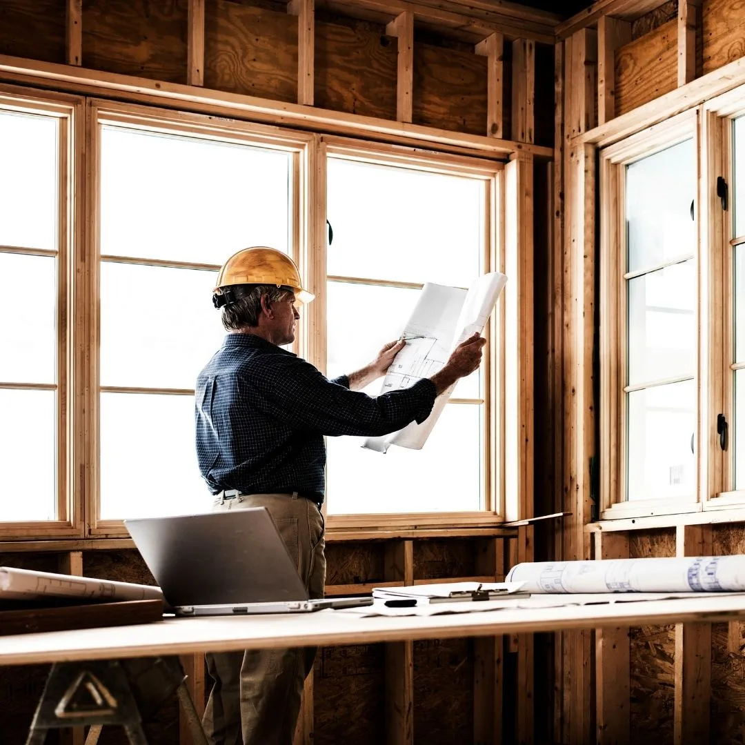 A home contractor reading custom home blueprints