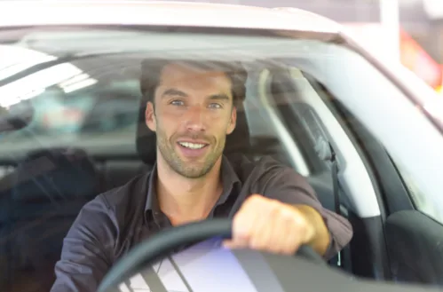 Guy Smiling Behind the Wheel of Car